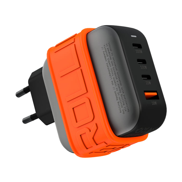 Essential GaN Charger - 100W power, 45% smaller - Essential GaN Charger - 100W power, 45% smaller - US - Compact black and gray 100W GaN charger with orange silicone protective band and EU plug, featuring four USB ports including . - Rolling Square Essential GaN Charger - 100W power, 45% smaller - US - Compact black and gray 100W GaN charger with orange silicone protective band and EU plug, featuring four USB ports including . - Rolling Square